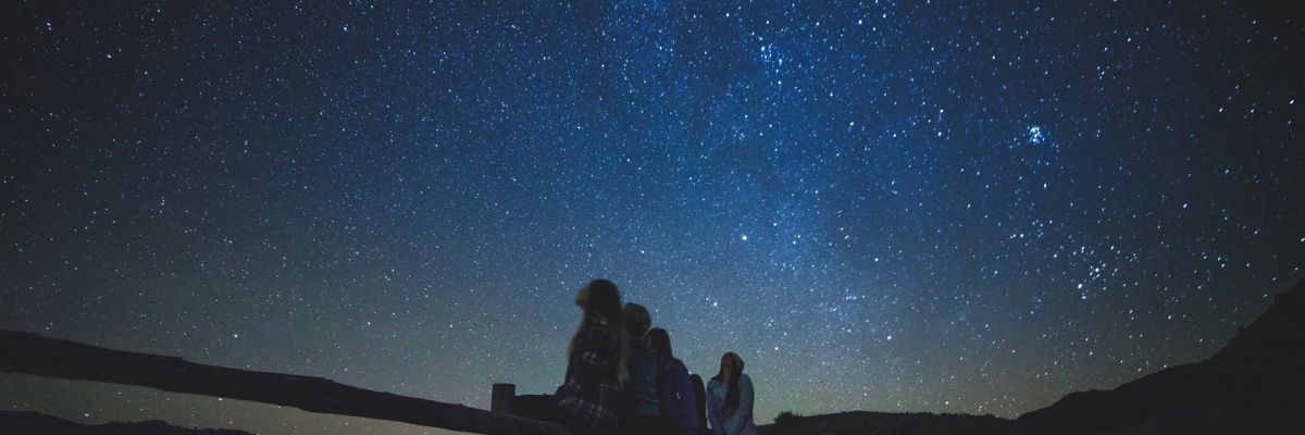 personas mirando cielo estrellado